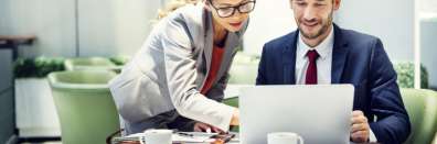 Two business associates reviewing contents on a laptop together. Conceptual IT