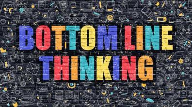 "Bottom Line Thinking" in graffiti-like writing on black wall