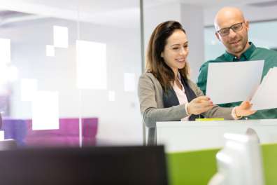 Professionals reviewing paper documents representing ECM