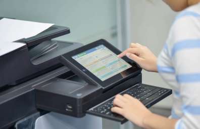 Woman selecting an option on an office copier's smart screen