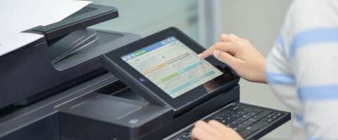 Woman selecting an option on an office copier's smart screen