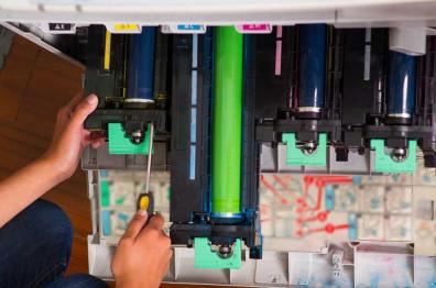 Close-up of technician working on large-format copier