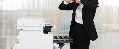 woman in business attire frustrated with a faulty office printer