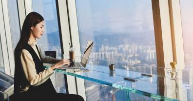 asian woman using laptop in high rise cafe