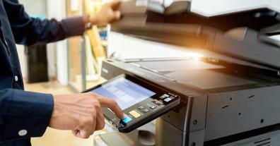 mans hand pushing button on copier