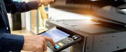 mans hand pushing button on copier