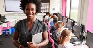 teacher in class holding tablet