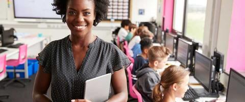 teacher in class holding tablet