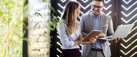 A Managed Services Provider reviews a laptop and tablet with a company employee during a consultation