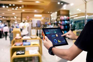 Employee working on a tablet in a retail store signifying business IT solutions.