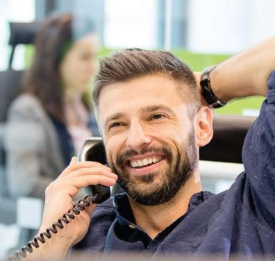 Man smiling while talking on the phone