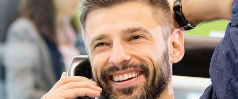 Man smiling while talking on the phone