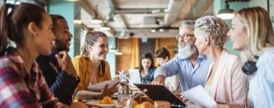 Group of employees happily enjoying a meeting around a conference table