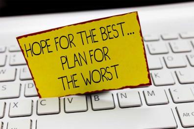 "Hope for the best...plan for the worst" sign on a yellow card placed on a white computer keyboard. This image emphasizes the importance of disaster recovery planning for businesses.