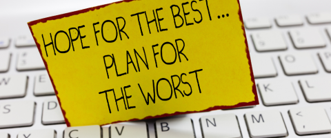"Hope for the best...plan for the worst" sign on a yellow card placed on a white computer keyboard. This image emphasizes the importance of disaster recovery planning for businesses.