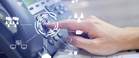 Close-up of a person pressing a button on a VoIP phone, with various icons representing VoIP features and connectivity options.