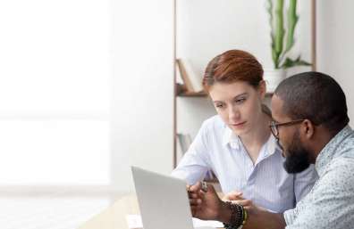 Two coworkers looking at a computer monitor