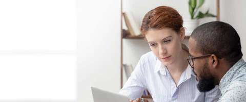 Two coworkers looking at a computer monitor