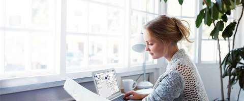 Woman working on laptop computer in home office